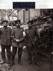 Drei Soldaten stehen auf dem Gehweg vor einem Wohngebäude
