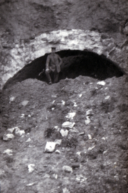 Mann steht vor einem historischen Steinbogen in den Bergen