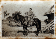 Ein Reiter auf einem Pferd vor einem ländlichen Hintergrund in der Dämmerung
