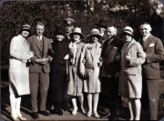 Eine Gruppe von neun Personen kleidet sich stilvoll im Park der 1920er Jahre