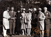 Eine Gruppe von neun Personen kleidet sich stilvoll im Park der 1920er Jahre