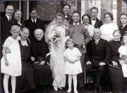 Hochzeitsfeier einer Familie in den 1940er Jahren vor einem Backsteinhaus