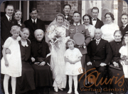 Hochzeitsfeier einer Familie in den 1940er Jahren vor einem Backsteinhaus