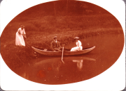 Drei Personen im Boot auf einem ruhigen See in der Natur im Sommer