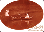 Drei Personen im Boot auf einem ruhigen See in der Natur im Sommer