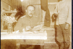 In einem schlichten Raum im Ersten Weltkrieg sitzt ein Soldat am Tisch
