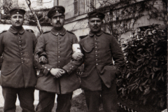 Drei Soldaten stehen auf dem Gehweg vor einem Wohngebäude
