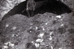 Mann steht vor einem historischen Steinbogen in den Bergen