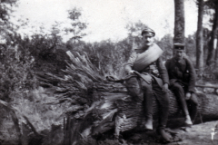 Zwei Soldaten sitzen auf einem umgestürzten Baum im Wald während des Krieges