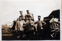 Soldaten posieren stolz vor einem historischen Militärfahrzeug im Freien