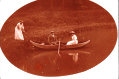Drei Personen im Boot auf einem ruhigen See in der Natur im Sommer