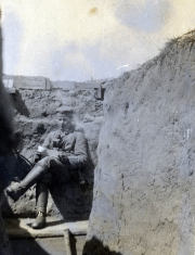 Soldat sitzt entspannt in einem Schützengraben an der Westfront während des Ersten Weltkriegs