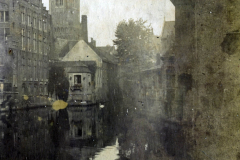 Blick auf den Kanal mit historischem Gebäude und Kirchturm in Brugge