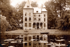 Historische Villa am Ufer eines ruhigen Teichs in Erneghem um 1900