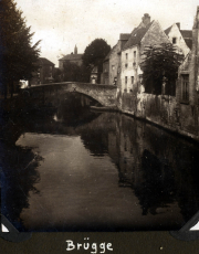 Eine ruhige Szene am Kanal in Brügge zeigt historische Gebäude und eine Steinbrücke