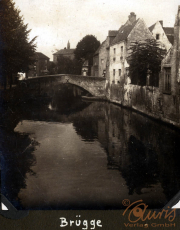 Eine ruhige Szene am Kanal in Brügge zeigt historische Gebäude und eine Steinbrücke