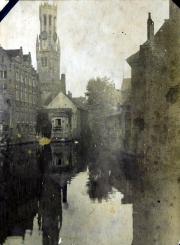 Blick auf den Kanal mit historischem Gebäude und Kirchturm in Brugge