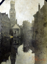 Blick auf den Kanal mit historischem Gebäude und Kirchturm in Brugge