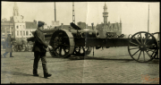 Soldat marschiert an einem Artilleriegeschütz vorbei in einer Stadt während des Ersten Weltkriegs