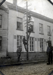 Arbeiter der Fernmeldeabteilung reparieren einen Telegraphenmast in einer Straße während des frühen 20. Jahrhunderts