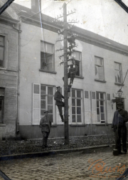Arbeiter der Fernmeldeabteilung reparieren einen Telegraphenmast in einer Straße während des frühen 20. Jahrhunderts
