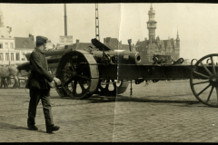 Soldat marschiert an einem Artilleriegeschütz vorbei in einer Stadt während des Ersten Weltkriegs