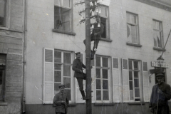 Arbeiter der Fernmeldeabteilung reparieren einen Telegraphenmast in einer Straße während des frühen 20. Jahrhunderts
