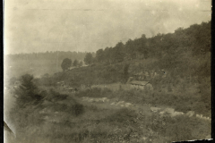 Historisches Heerlager in bergiger Landschaft mit Bäumen und Ruinen