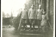 Vier Soldaten der Heer stehen ehemalig auf einer Treppe vor einem Gebäude in Deutschland zur Zeit des Ersten Weltkriegs