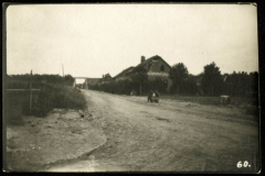 Eine ländliche Straße mit einem Haus und einer Person auf dem Boden in der Nähe eines beschaulichen Gebiets