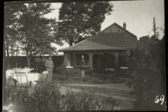 Soldat vor einem Gartenhaus mit Tischen und Stühlen in einer ländlichen Umgebung