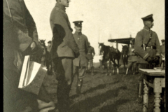 Militärische Versammlung mit Offizieren und Pferden auf einem Feld bei Tageslicht