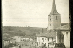 Eine ländliche Straße mit Kirche und Häusern in historischer Landschaft