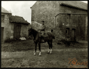 Soldat auf einem Pferd vor einer alten Steinhütte in ländlicher Umgebung