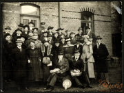 Gruppenaufnahme von Männern und Frauen in historischen Outfits vor einem Backsteingebäude
