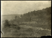 Historisches Heerlager in bergiger Landschaft mit Bäumen und Ruinen