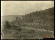 Historisches Heerlager in bergiger Landschaft mit Bäumen und Ruinen