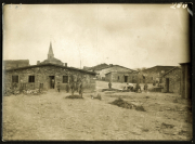 Heer in einer historischen Siedlung mit Steinhäusern und Kirche im Hintergrund bei Tageslicht
