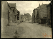 Ruine eines kleinen Dorfes nach dem Krieg, mit beschädigten Gebäuden und einer leeren Straße