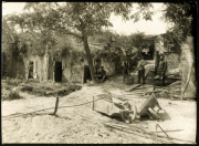 Arbeiter im Freien neben einer Ruine mit Werkzeug und Baum im Hintergrund