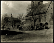 Heer zieht in eine Stadt mit Pferdewagen und einem historischen Gebäude im Hintergrund