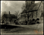 Heer zieht in eine Stadt mit Pferdewagen und einem historischen Gebäude im Hintergrund