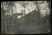 Bau eines Holzhauses im Wald mit einer Person und umgebenden Bäumen