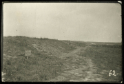 Karge Landschaft mit Trümmern und Wegweiser im Vordergrund bei Heer