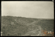 Karge Landschaft mit Trümmern und Wegweiser im Vordergrund bei Heer
