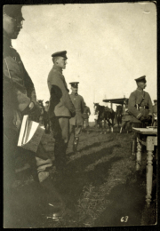 Militärische Versammlung mit Offizieren und Pferden auf einem Feld bei Tageslicht