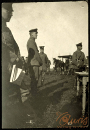 Militärische Versammlung mit Offizieren und Pferden auf einem Feld bei Tageslicht