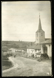 Eine ländliche Straße mit Kirche und Häusern in historischer Landschaft