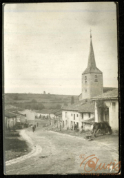 Eine ländliche Straße mit Kirche und Häusern in historischer Landschaft