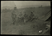 Soldaten sitzen in einem Feld nahe einem Zelt und unterhalten sich während des Ersten Weltkriegs